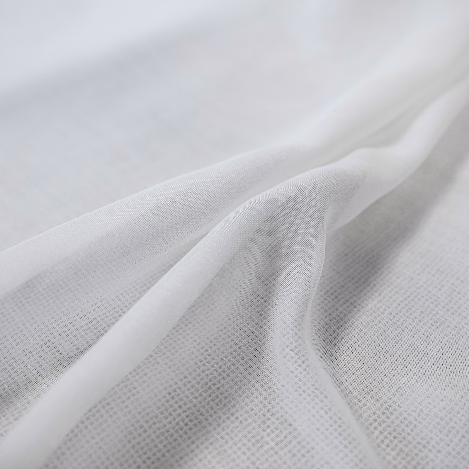 Cool white fabric with a fine open weave draped into soft flowing folds