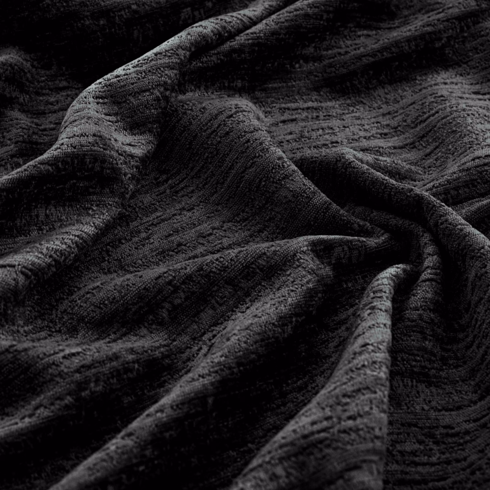 Near-black Torino textile with rippled charcoal ridges folded into deep shadows