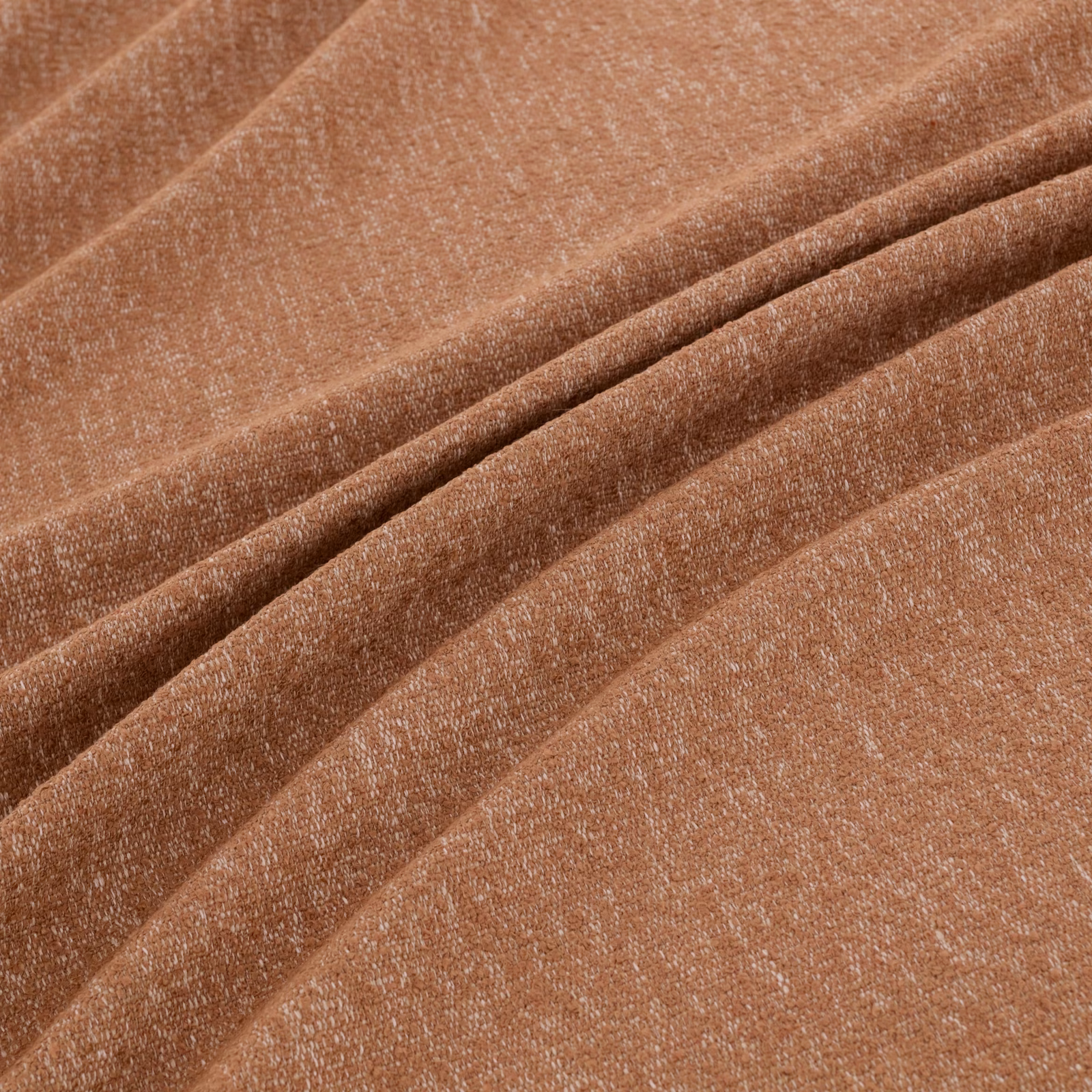 Warm clay terracotta woven fabric with fine texture, folded into soft ridges
