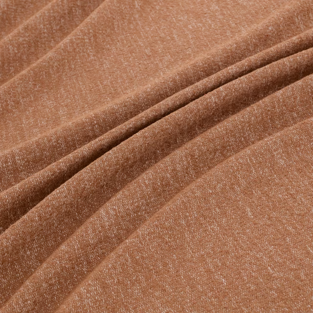 Warm clay terracotta woven fabric with fine texture, folded into soft ridges