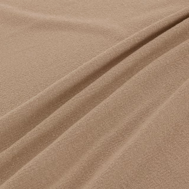 Warm oat-beige plain fabric with softly brushed texture arranged in broad folds