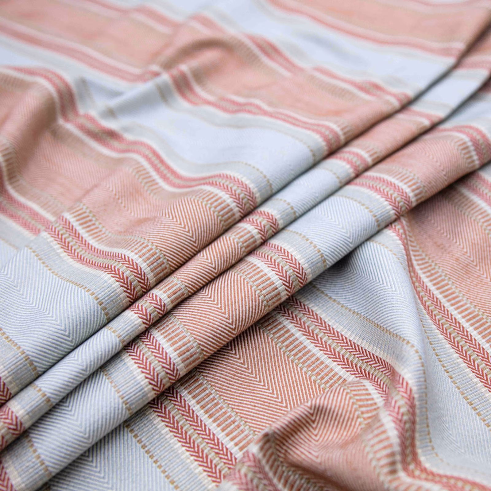 Blush pink and powder blue woven fabric with flowing bands and herringbone texture