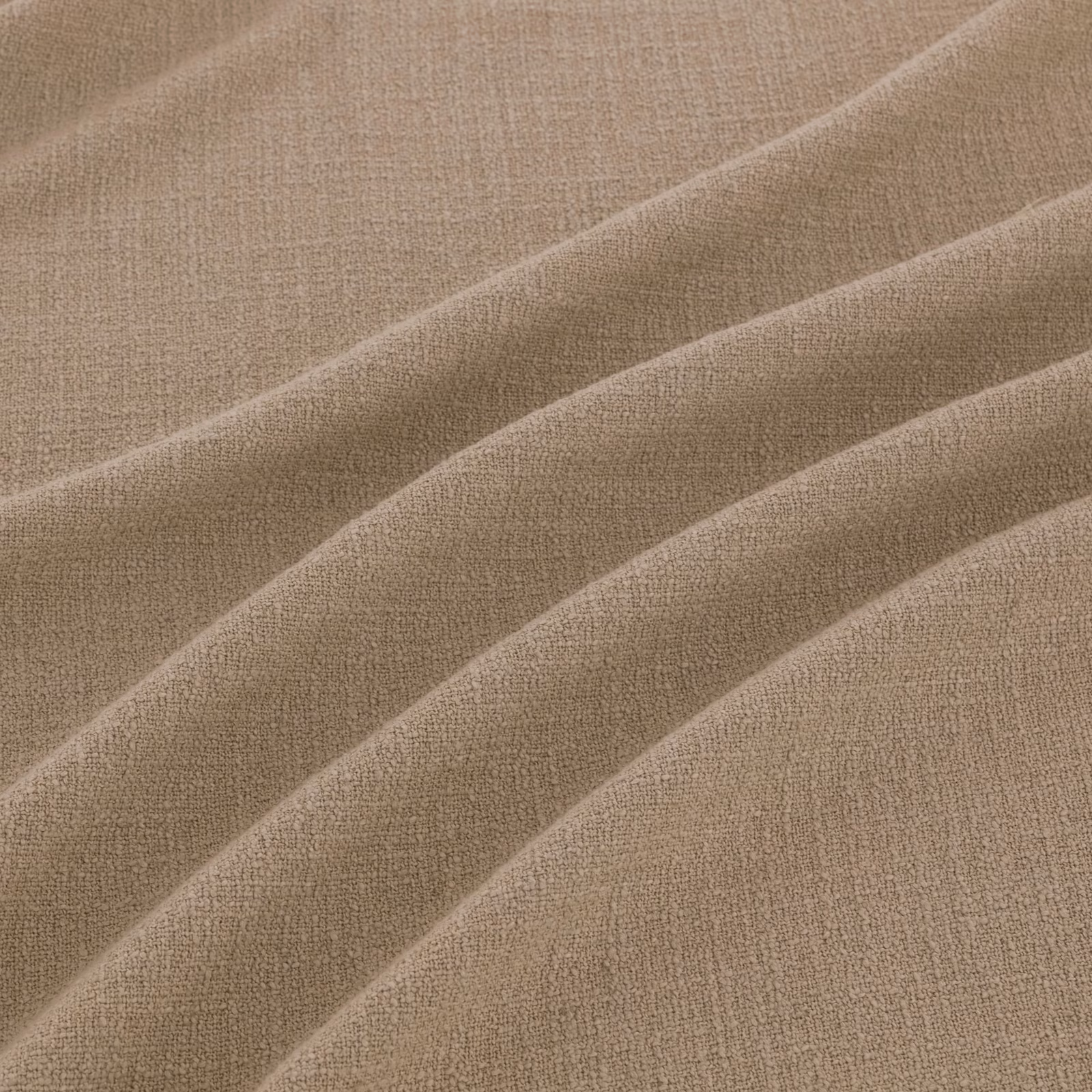 Warm flax taupe fabric with fine woven texture arranged in soft diagonal folds