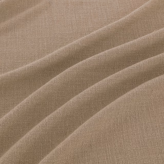 Warm flax taupe fabric with fine woven texture arranged in soft diagonal folds