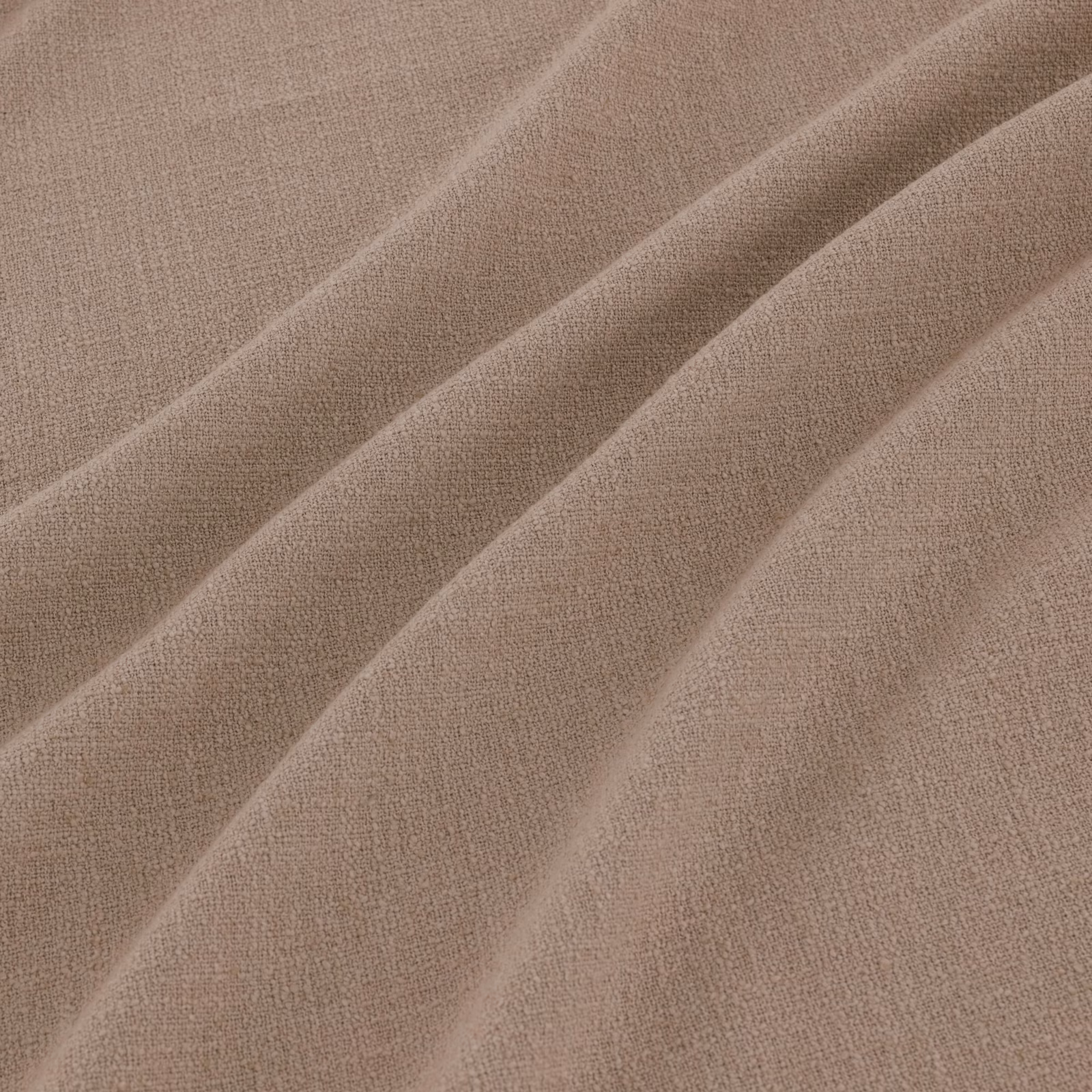 Warm oatmeal taupe woven fabric falling into broad, softly textured diagonal folds