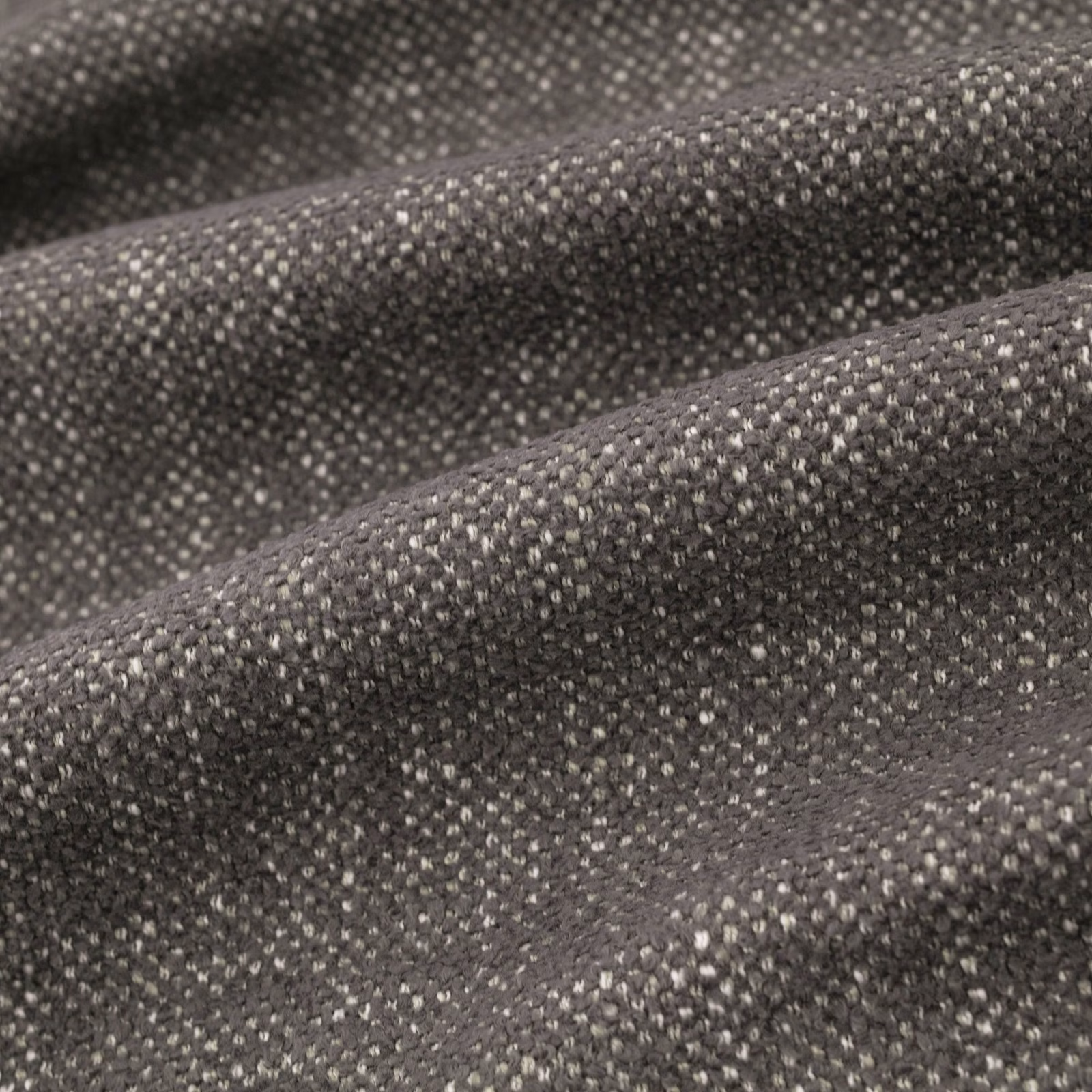 Close-up of Verona Granite’s charcoal-grey flecked weave folded into soft ridges