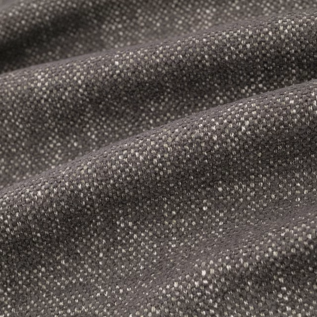 Close-up of Verona Granite’s charcoal-grey flecked weave folded into soft ridges