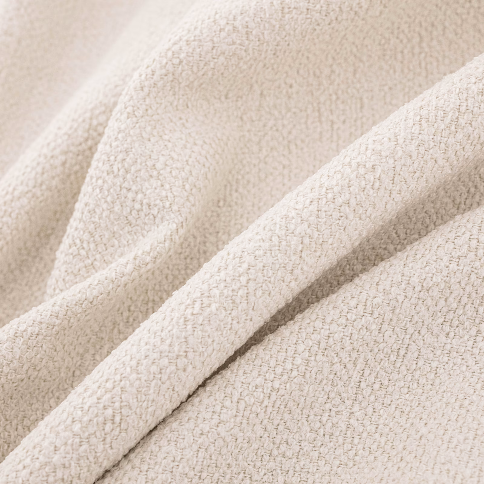 Warm ivory fabric with a small nubby boucle weave arranged in soft folds