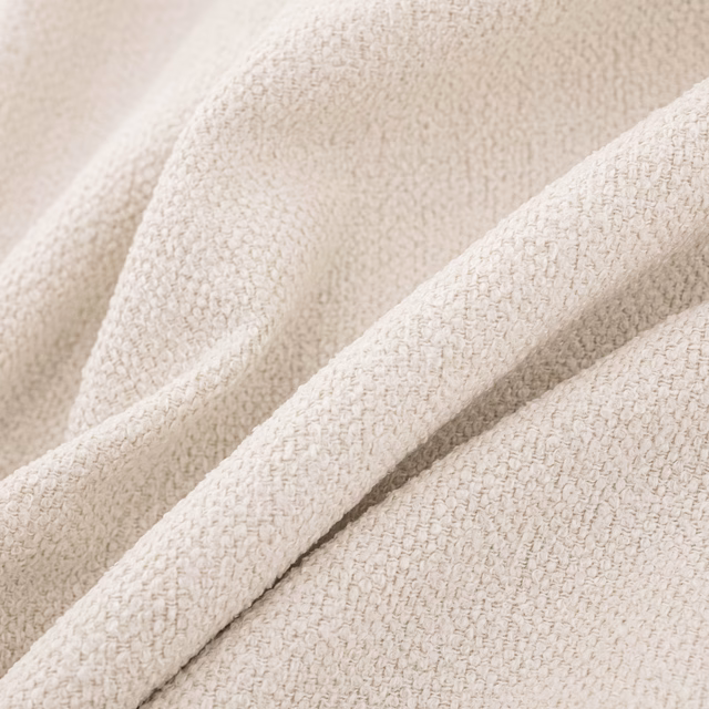 Warm ivory fabric with a small nubby boucle weave arranged in soft folds