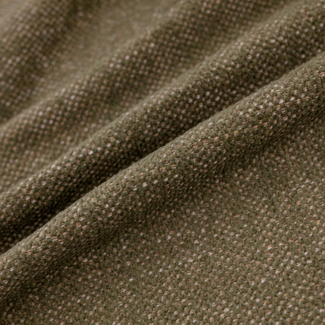 Close-up of muted moss-green woven upholstery with a nubby, flecked texture