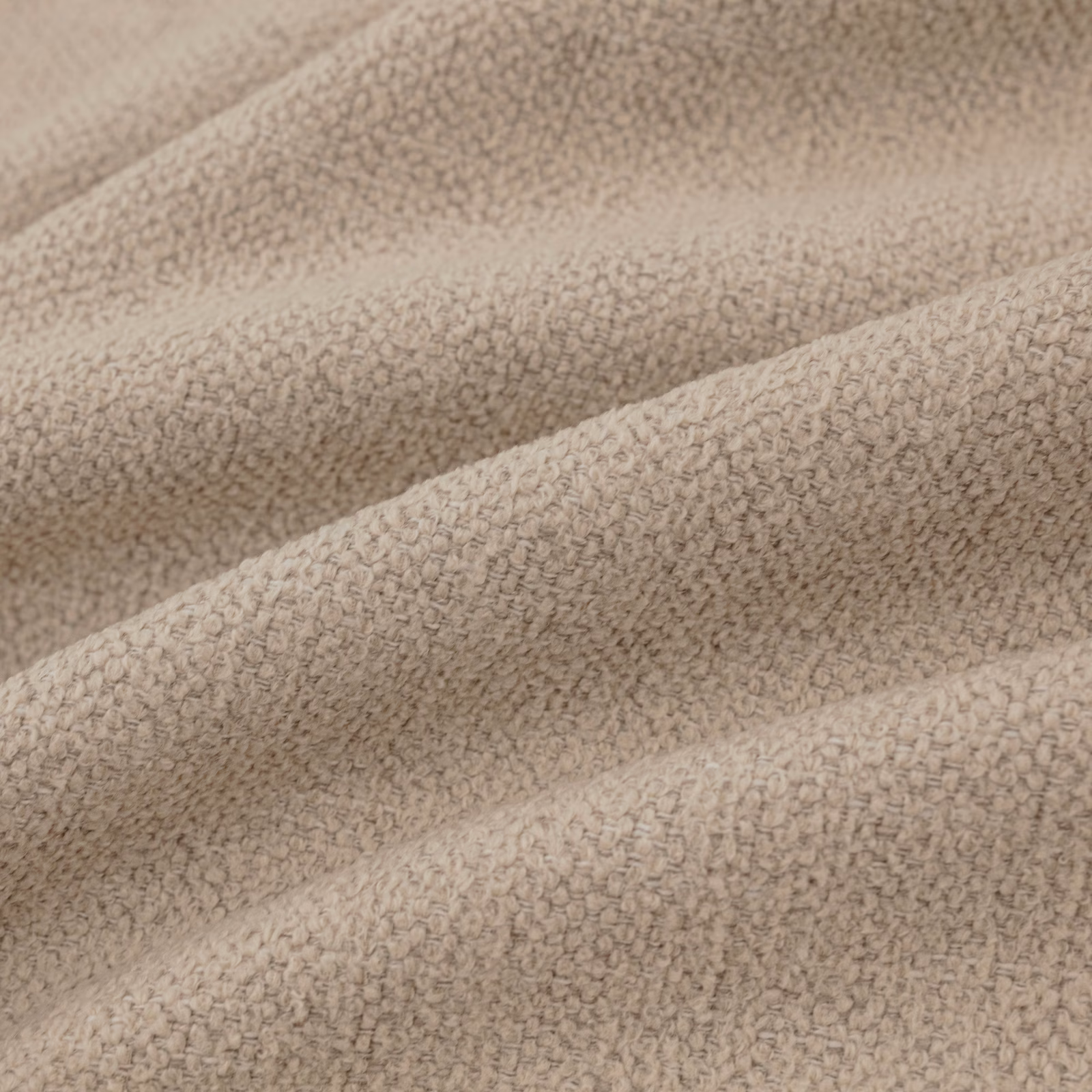 Warm oatmeal textile with a compact pebbled loop weave folded into soft ridges