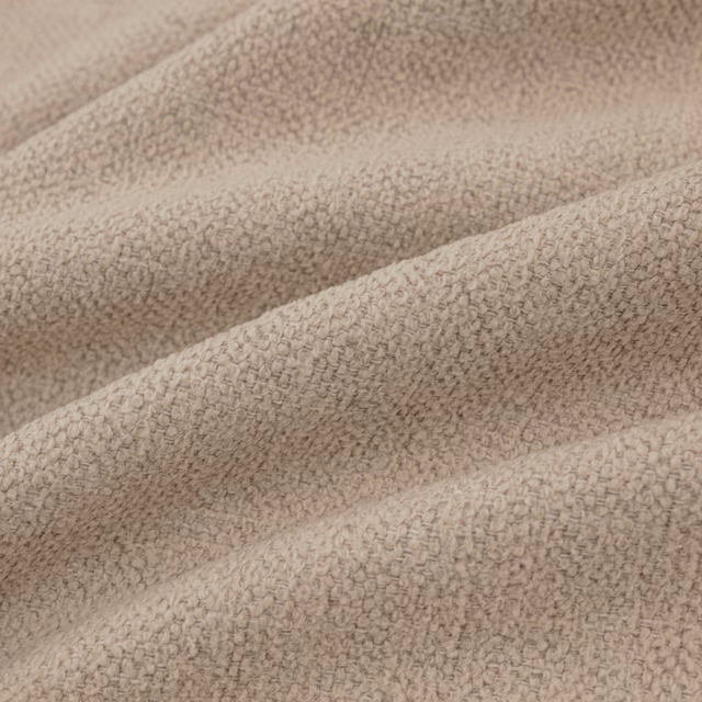 Warm oatmeal textile with a compact pebbled loop weave folded into soft ridges
