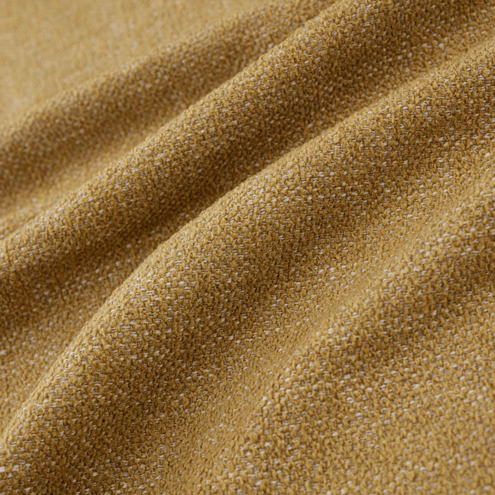 Close-up of warm ochre woven fabric with golden flecks and nubby texture