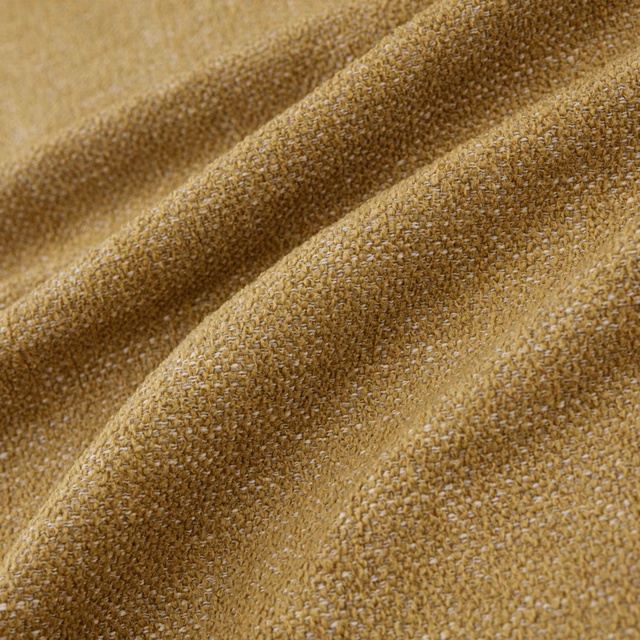 Close-up of warm ochre woven fabric with golden flecks and nubby texture