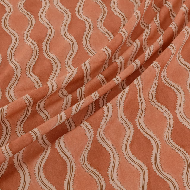 Muted coral terracotta fabric with cream serpentine stripes and softly textured surface