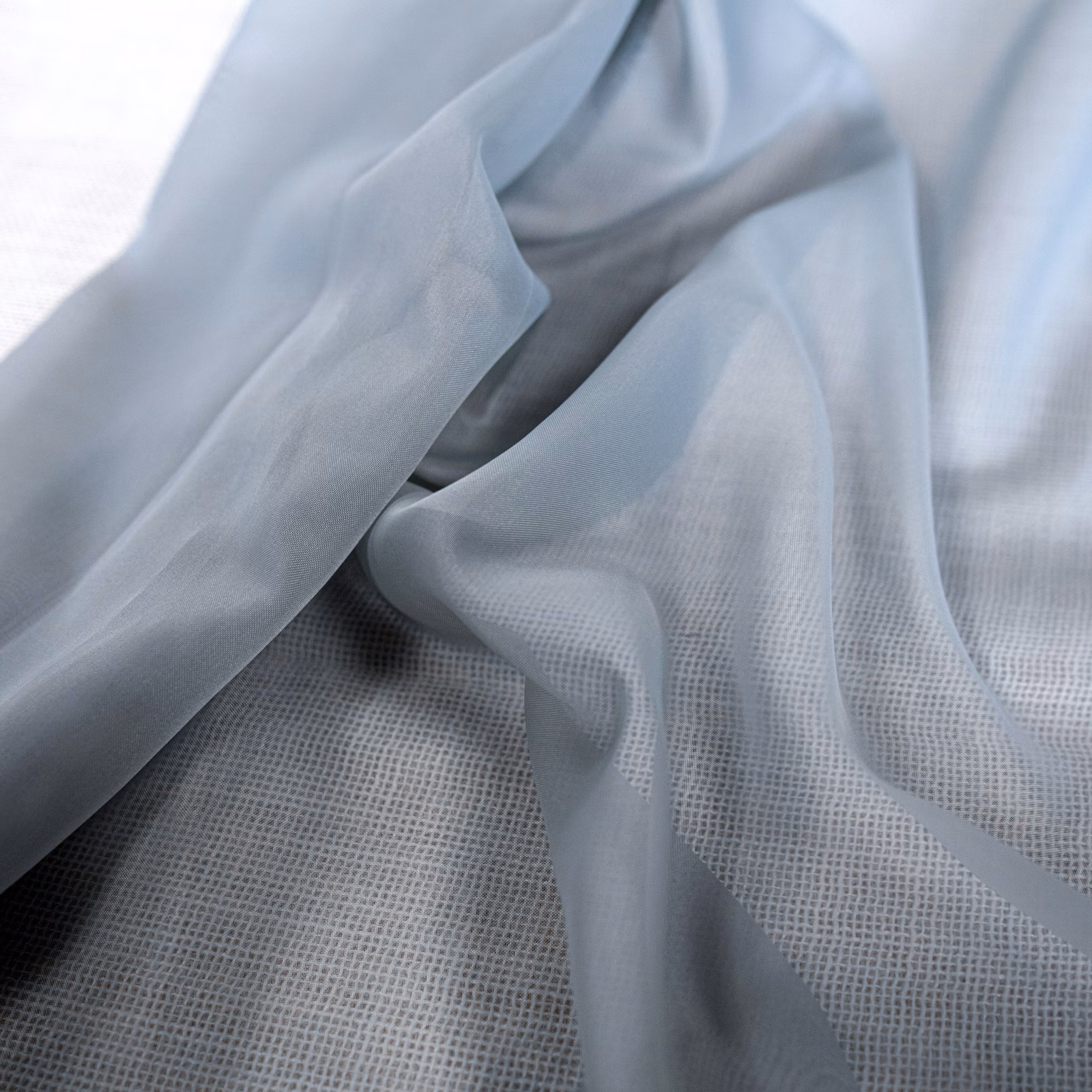 Pale blue-grey sheer fabric draped to reveal its fine translucent weave