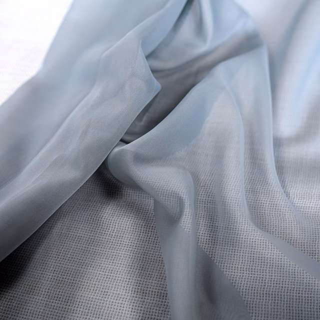 Pale blue-grey sheer fabric draped to reveal its fine translucent weave