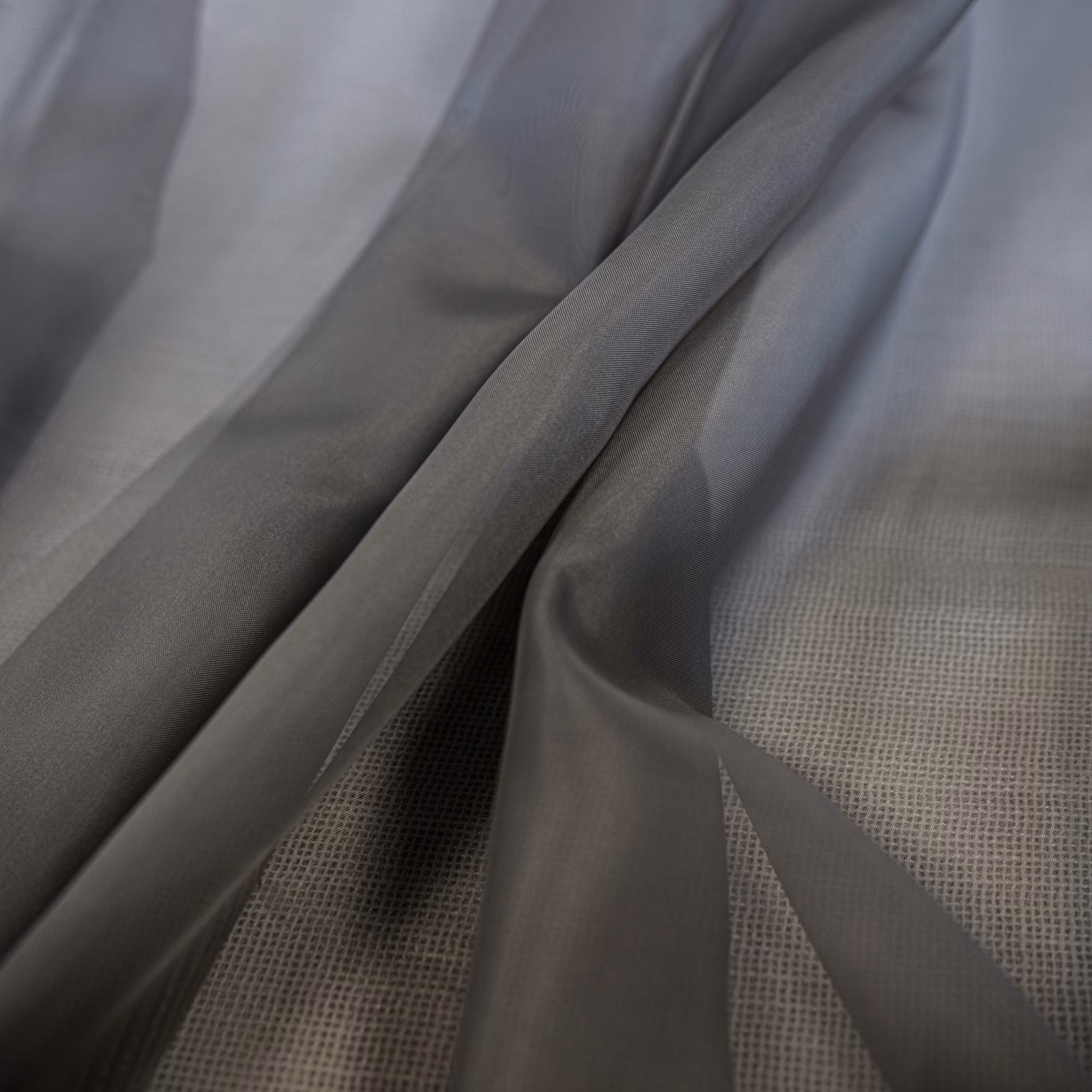Cool smoky-grey sheer fabric with a fine grid weave draped in soft folds