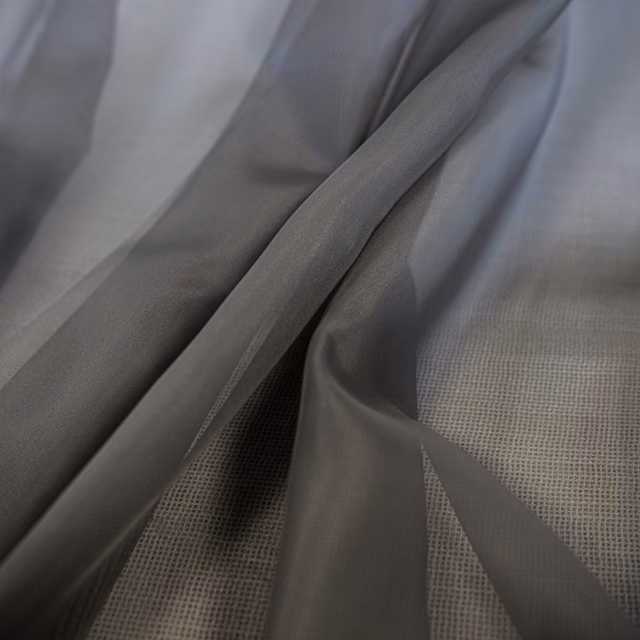Cool smoky-grey sheer fabric with a fine grid weave draped in soft folds