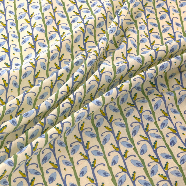 Cream fabric with repeating blue leaves, green stems and yellow botanical accents