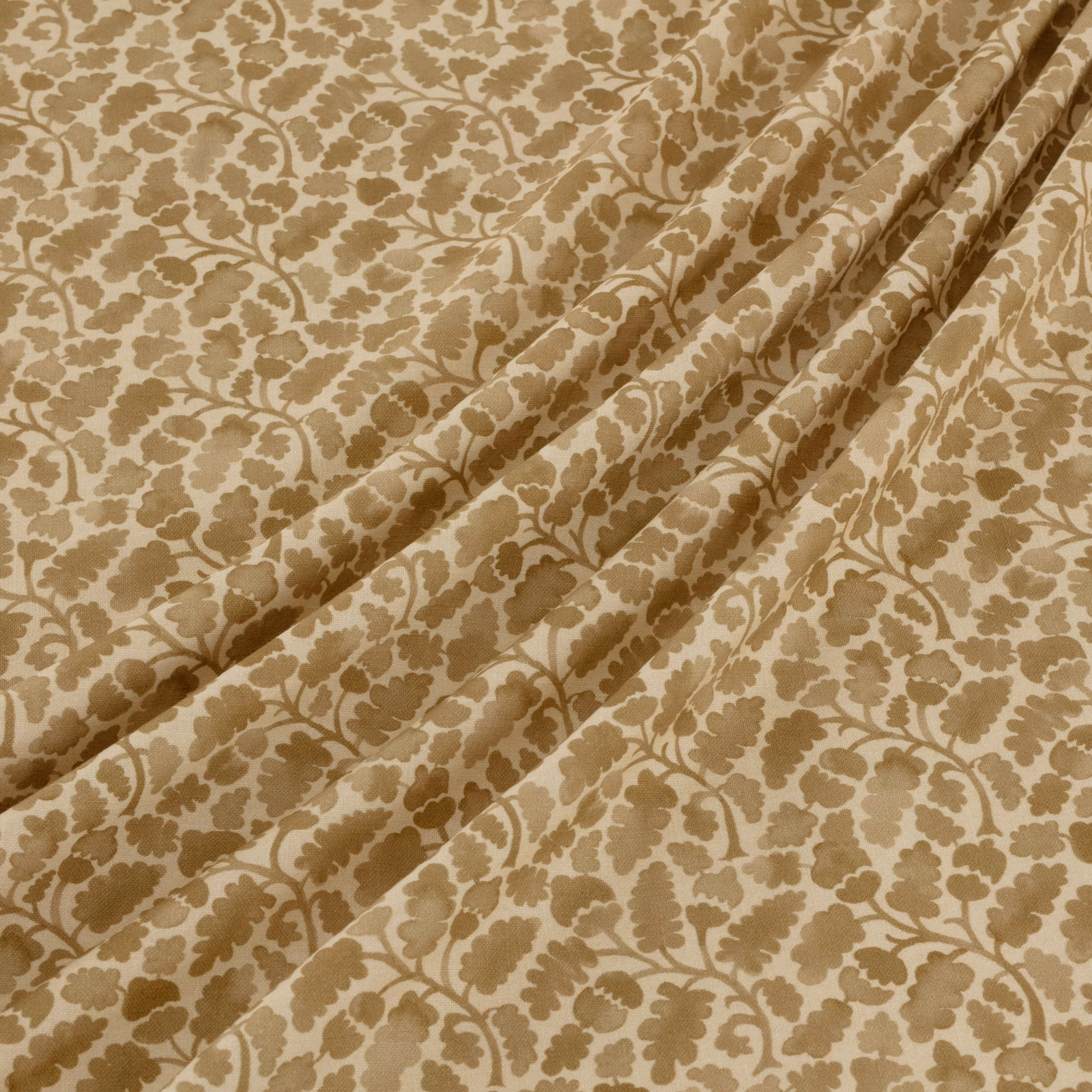 Warm beige textile with taupe-brown floral vines, leafy motifs and soft folds