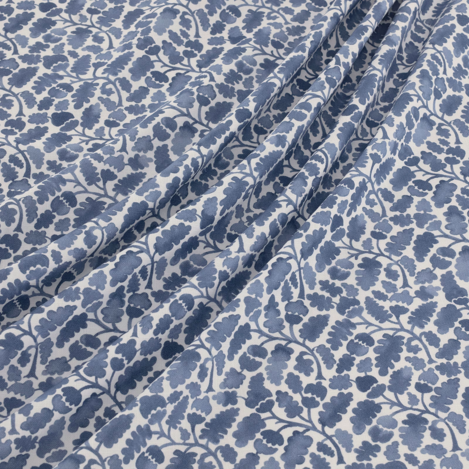 Dusty blue botanical vines and leaves on a pale blue-grey ground
