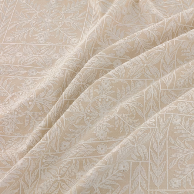 Warm ivory beige fabric with tonal leafy botanical motifs and soft flowing folds