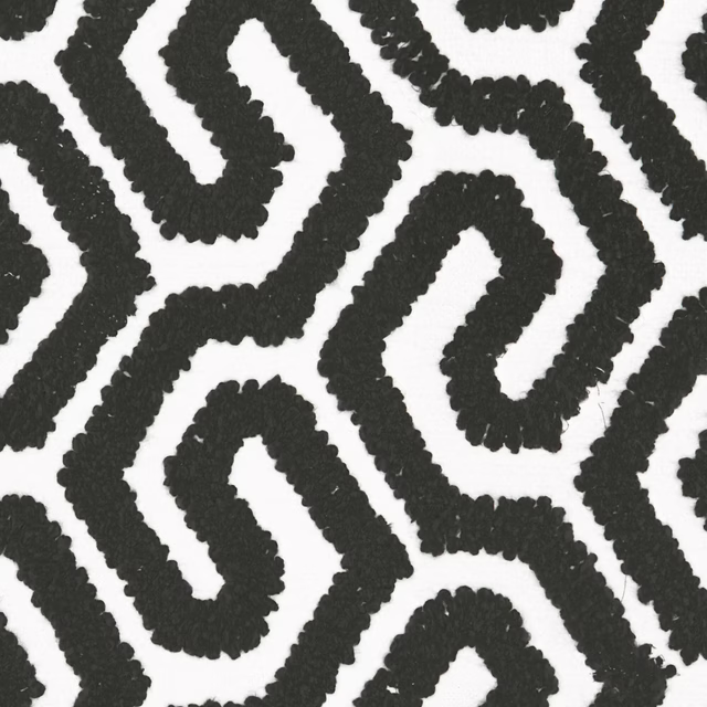 Raised black meandering bands across a white nubby geometric fabric ground