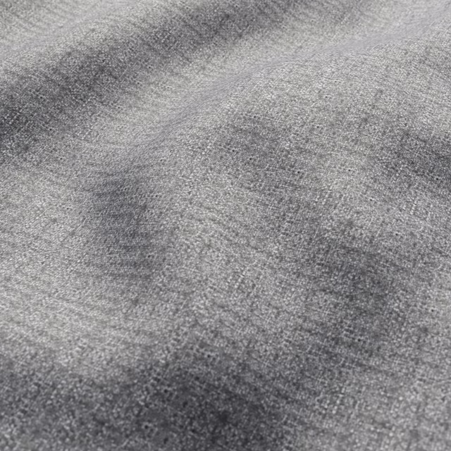Close-up of cool grey fabric with fine weave and softly mottled charcoal shading