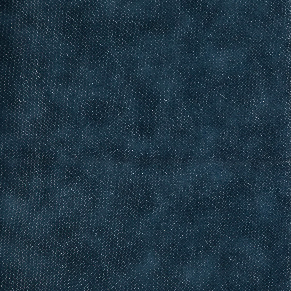 Close-up of dark indigo fabric with fine woven texture and softly mottled blue shading
