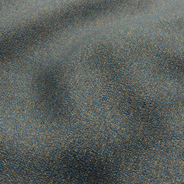 Close-up of muted blue-grey woven textile with taupe flecks and softly mottled shading.