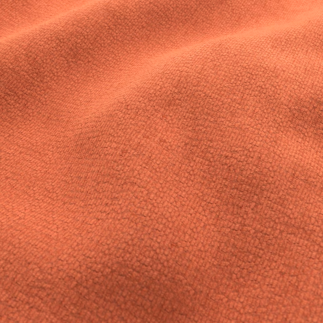 Warm dark coral textile with a dense, finely pebbled woven texture