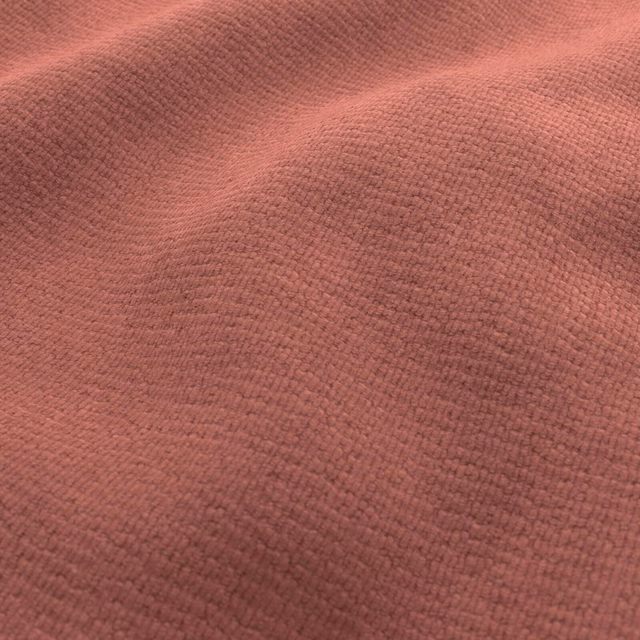 Close-up of dusty rose-mahogany fabric with a dense nubby woven texture