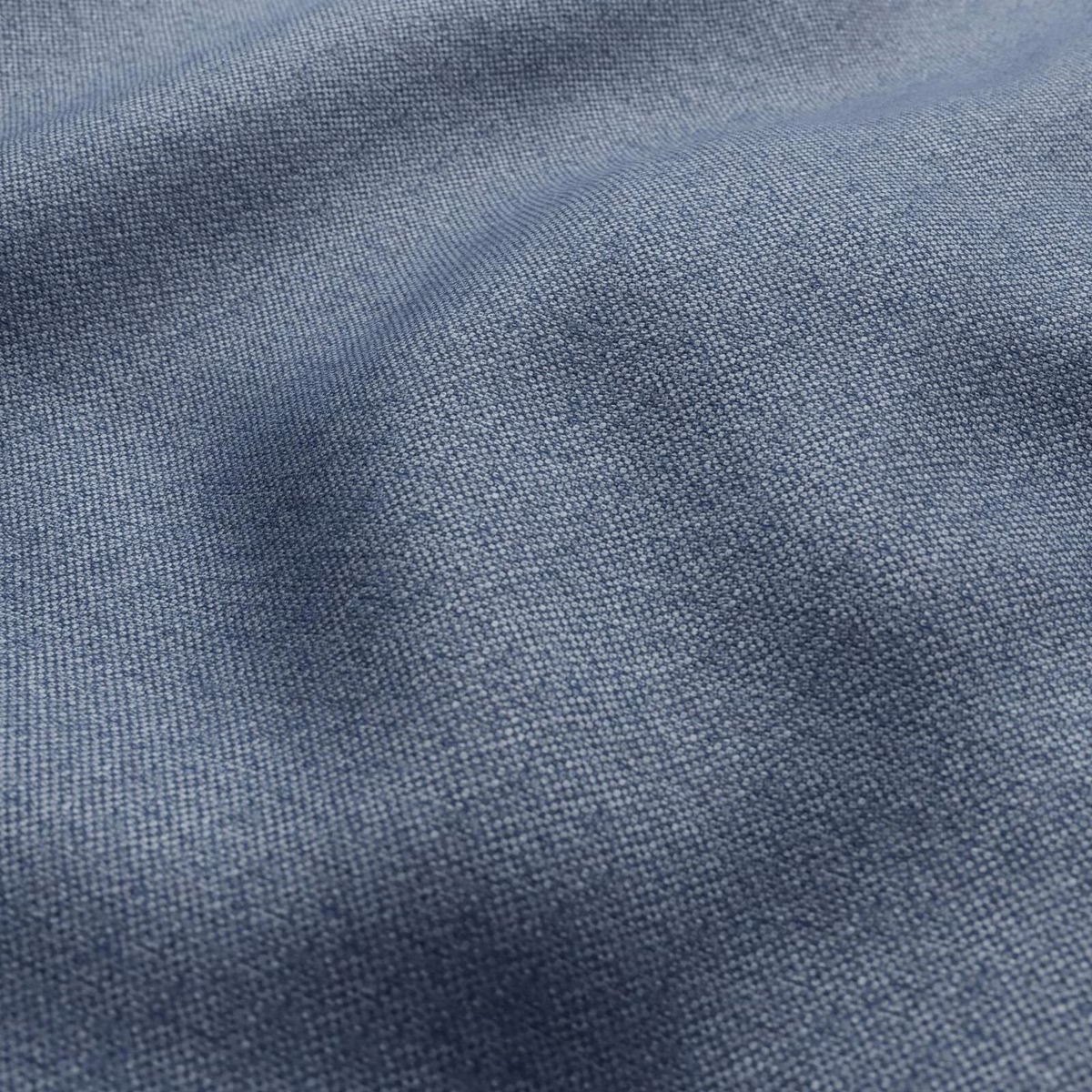 Close-up of muted blue-grey woven fabric with softly mottled slate texture