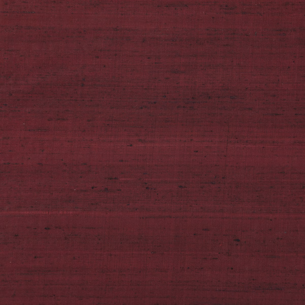 Deep claret-red Komodo Silk with dark horizontal striations and irregular woven texture