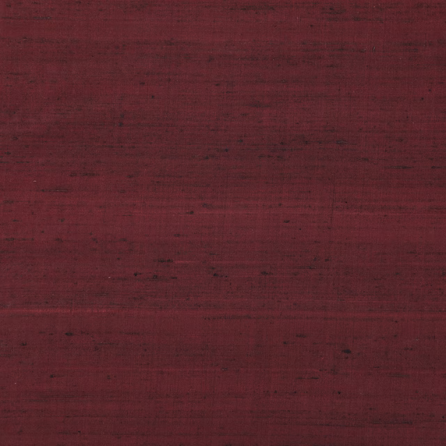 Deep claret-red Komodo Silk with dark horizontal striations and irregular woven texture