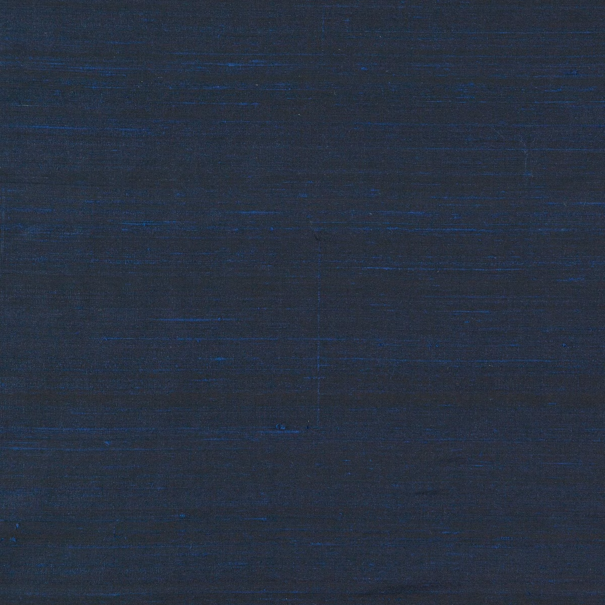 Deep indigo textile with fine horizontal slubs and subtle crosshatched texture