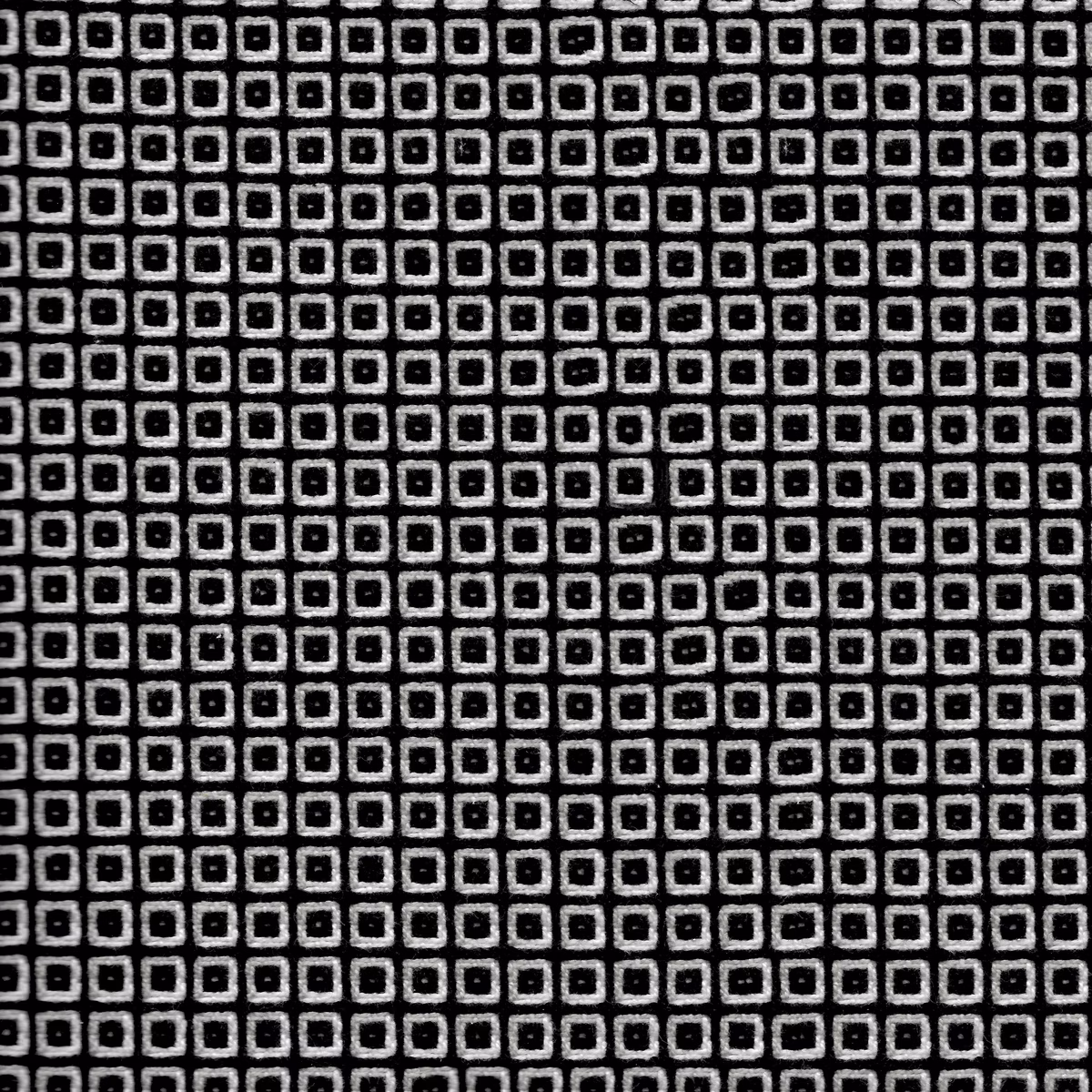Black woven fabric with tightly repeated chalk outlined squares in a grid
