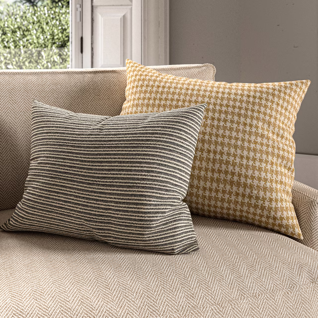 Warm citrine and ivory houndstooth woven cushion with a softly textured surface