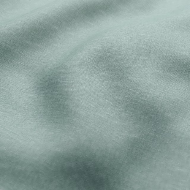 Pale sage-green fabric with cloudy tonal shading over a fine woven surface