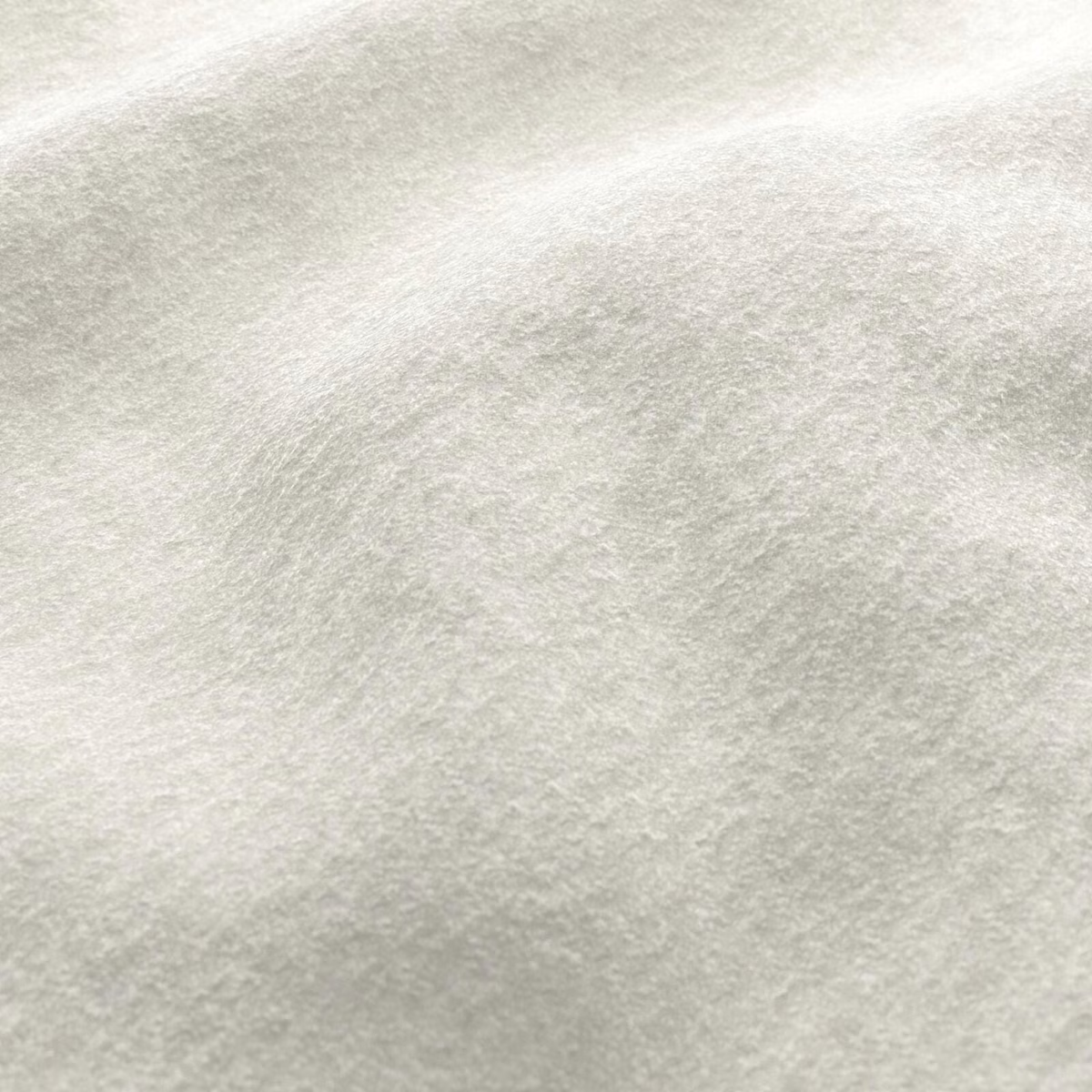 Close-up of pale cream fabric with a plush, softly mottled brushed surface
