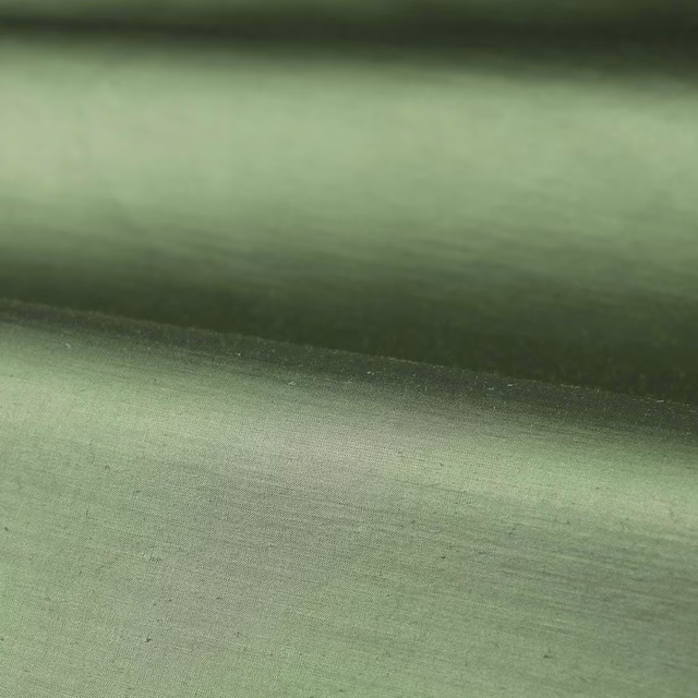 Muted jade-green plain weave showing fine horizontal texture and soft tonal shading