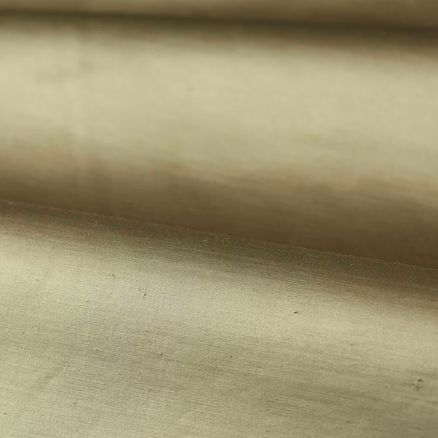 Close-up of softly lustrous muted sage-green plain fabric with fine horizontal weave