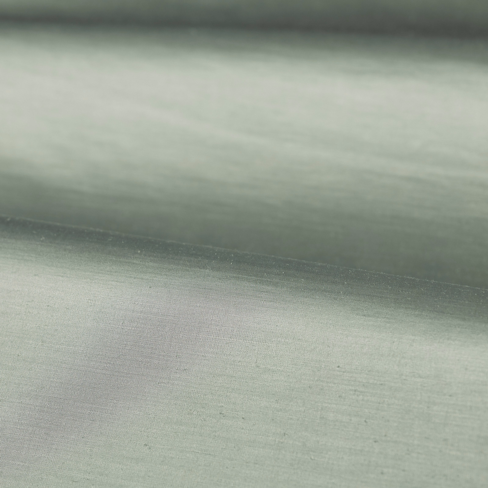 Misted blue-green plain weave with soft grey shading and a folded edge