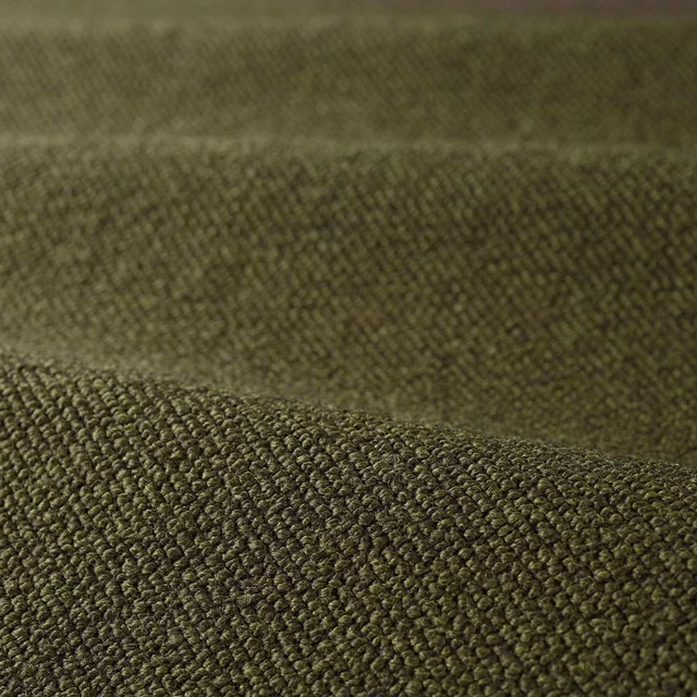 Deep moss olive bouclé fabric showing dense rounded loops and tactile folded texture