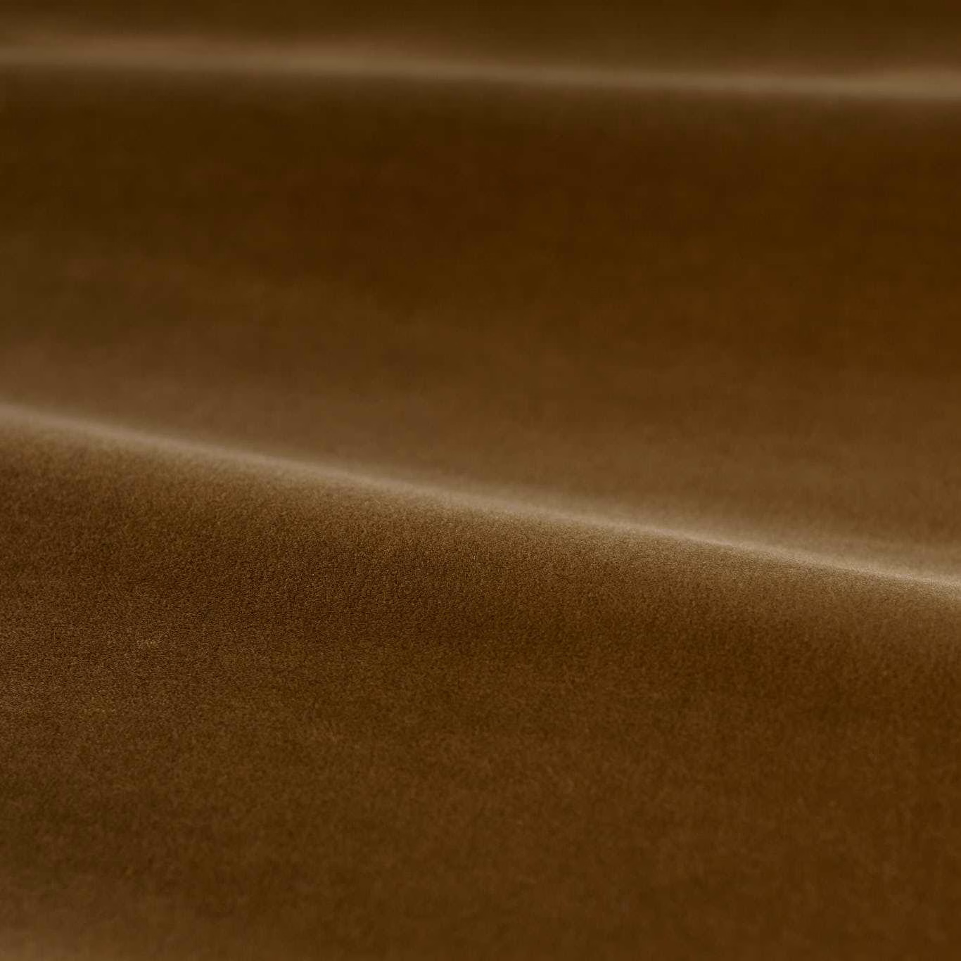 Deep camel-brown velvet swatch showing a smooth pile and bright fold highlight