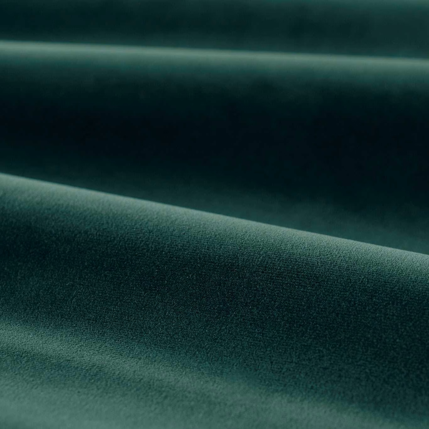 Deep emerald green plain velvet folded to show soft sheen and dark tonal shading