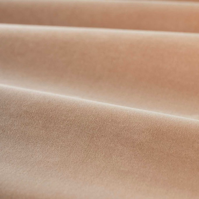 Warm rose-pink plain velvet showing plush directional pile and softly shaded folds