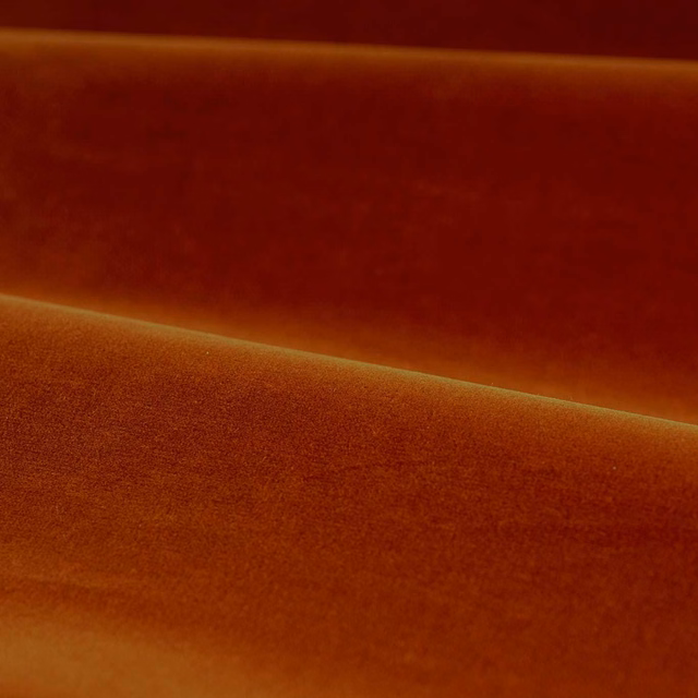 Burnt terracotta velvet with deep red shading and softly illuminated nap
