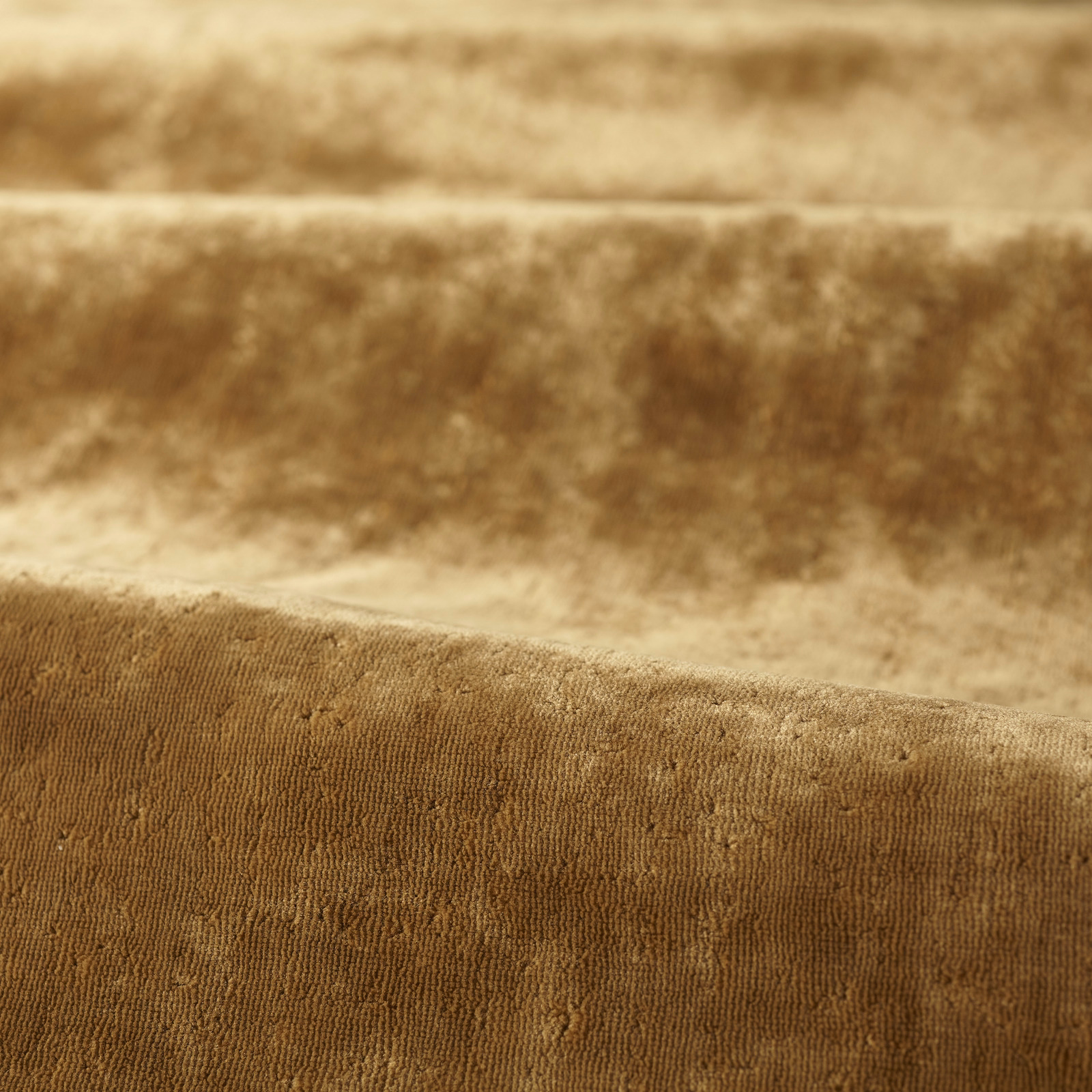 Close-up of warm amber-brown plain pile with fine vertical ribbing and soft sheen